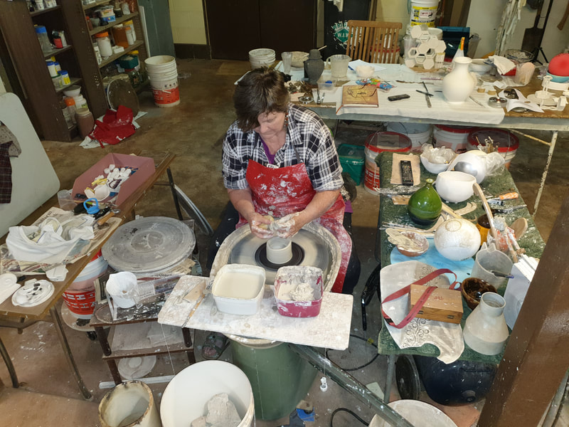 The artist, Rae Delai at the pottery wheel and in the workshop. Photograph of the urn made for Ena